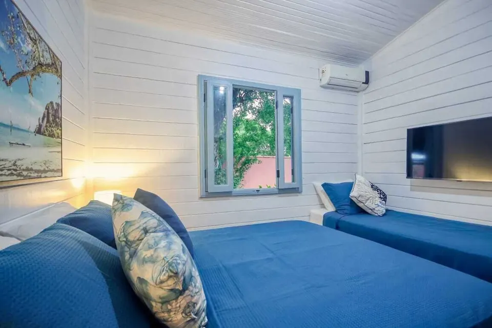 Air-conditioned blue guest bedroom at The Club House Búzios