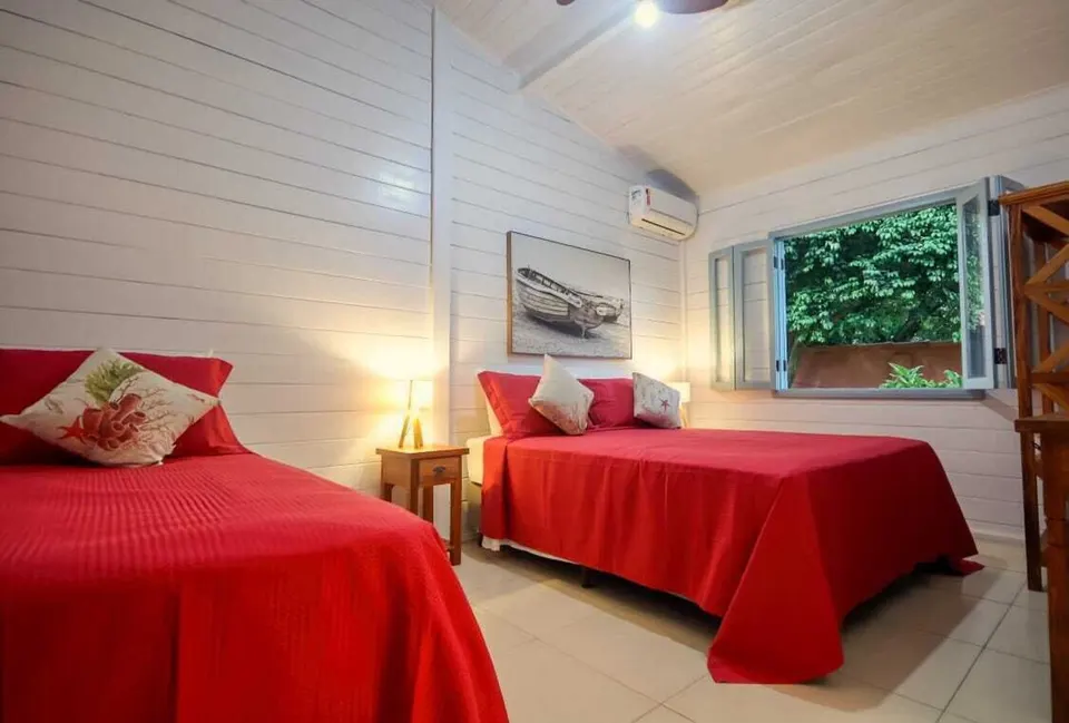 Air-conditioned bedroom with two red beds