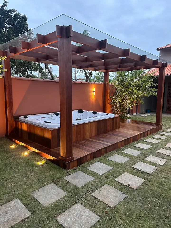 Outdoor hot tub beneath a wooden pergola